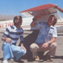 Brian Dinelli as a student kneeling next to an airplane.