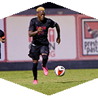 A men's soccer dribbles the ball.