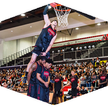 CSUN redshirt sophomore Kobe Paras dunks over two teammates. 