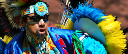 Native American dance at Powwow, dressed in bright,featherd costume