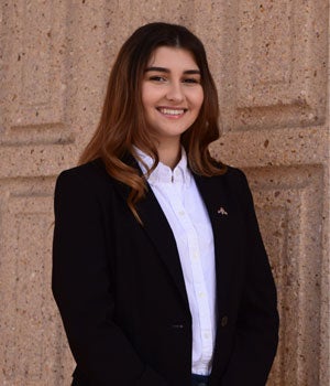 Female Student, Megi Gazi, wearing a white button up shirt