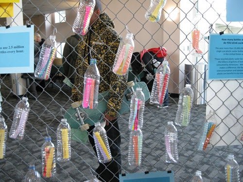 Recycled bottles hang from a fence