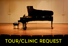 Tour-Clinic link. Piano on a darkened stage.