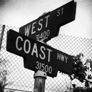 Corner street sign. Top says west and the bottom sign says coast