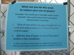 Blue sign informs what one can do this week to reduce their use of plastic