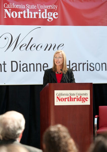 Dianne F. Harrison speaking in front of a podium