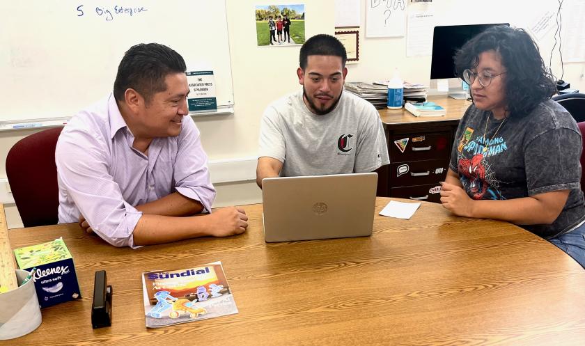 A professor meets with 2 students at a round table