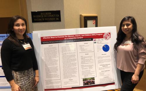 Student interns with research presentation board