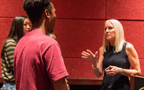 Michelle Vicary talking to two students after the panel discussion