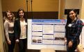 Student interns with research presentation board