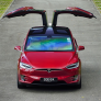 Front view of electric vehicle with wing doors open by Tesla