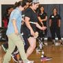 PT students lead person with prosthetic leg in a walking exercise