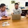 A professor meets with 2 students at a round table